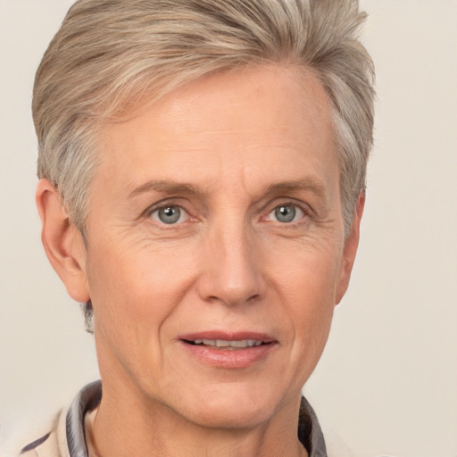 Joyful white middle-aged female with short  blond hair and grey eyes