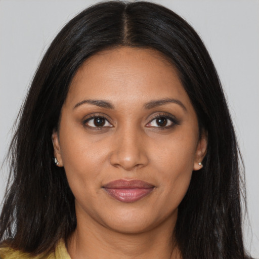 Joyful black young-adult female with long  brown hair and brown eyes