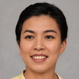 Joyful asian young-adult female with short  brown hair and brown eyes