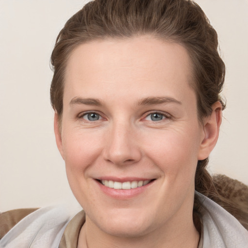 Joyful white young-adult female with short  brown hair and grey eyes