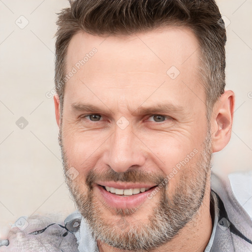 Joyful white adult male with short  brown hair and brown eyes