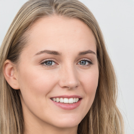 Joyful white young-adult female with long  brown hair and blue eyes