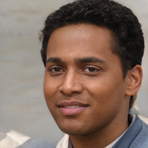 Joyful black young-adult male with short  black hair and brown eyes