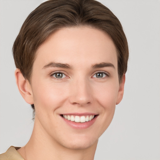 Joyful white young-adult female with short  brown hair and grey eyes