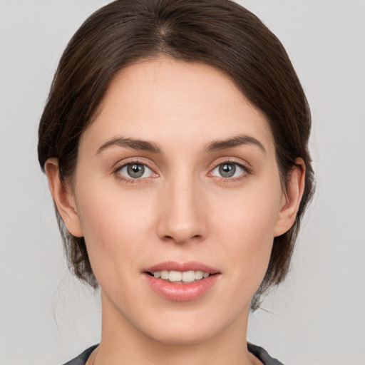 Joyful white young-adult female with medium  brown hair and grey eyes