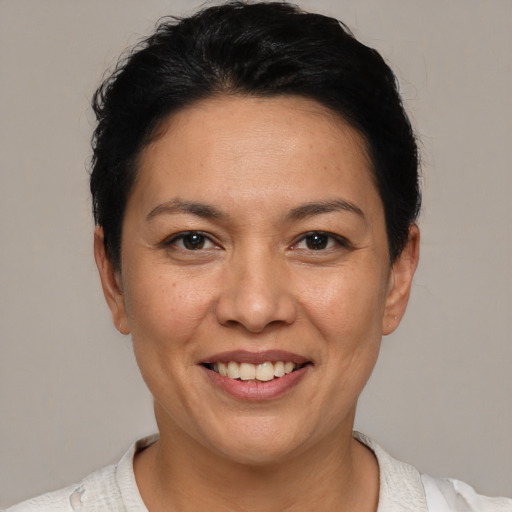 Joyful white adult female with short  black hair and brown eyes