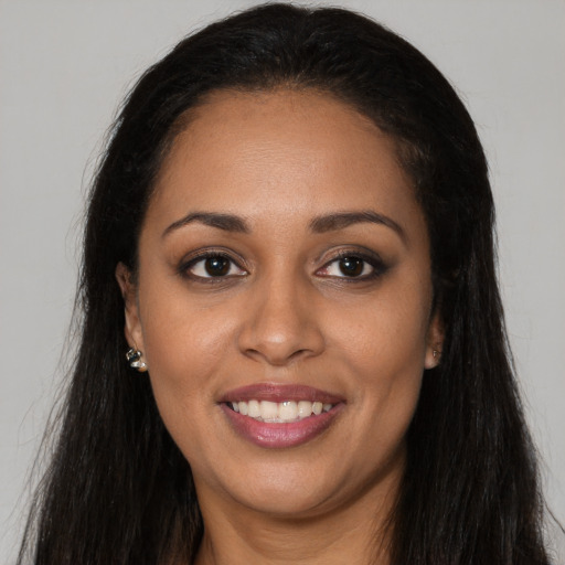 Joyful black young-adult female with long  brown hair and brown eyes