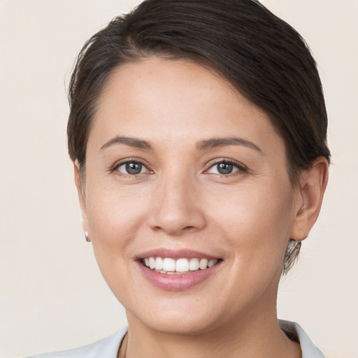 Joyful white young-adult female with short  brown hair and brown eyes