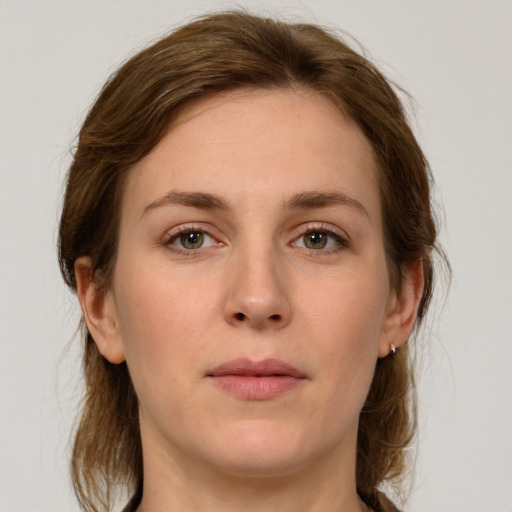 Joyful white young-adult female with medium  brown hair and green eyes