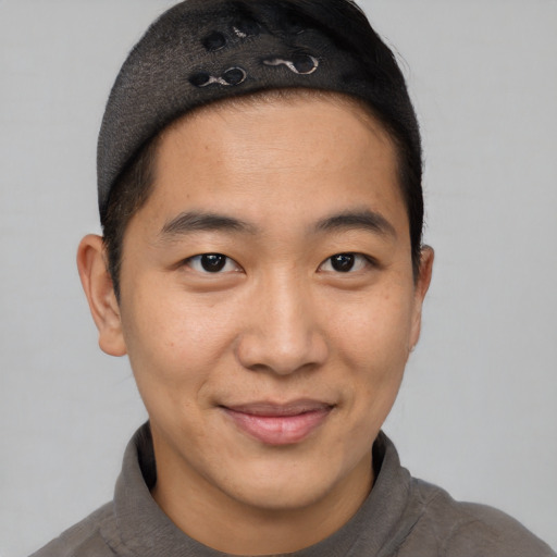 Joyful asian young-adult male with short  brown hair and brown eyes