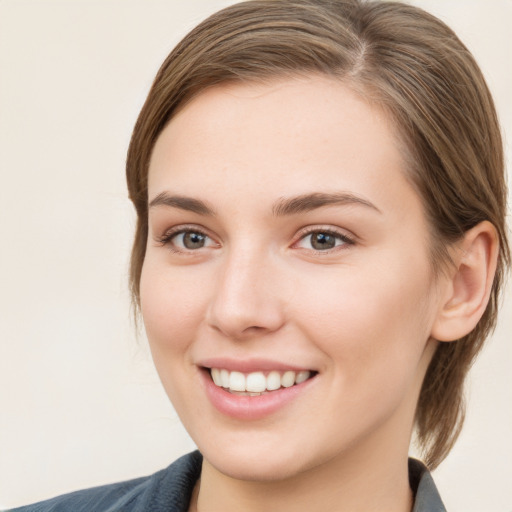 Joyful white young-adult female with medium  brown hair and grey eyes