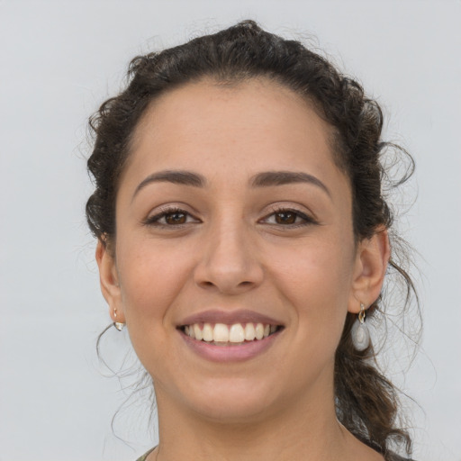 Joyful latino young-adult female with long  brown hair and brown eyes