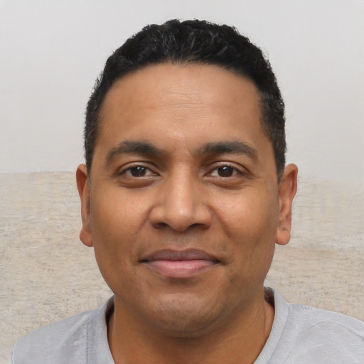 Joyful latino young-adult male with short  black hair and brown eyes