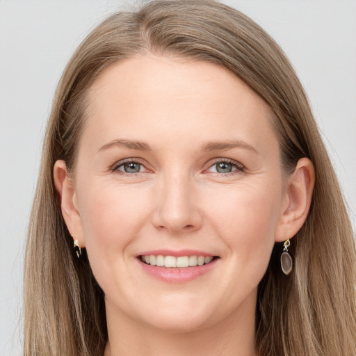 Joyful white young-adult female with long  brown hair and blue eyes