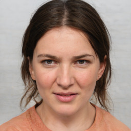 Joyful white young-adult female with medium  brown hair and blue eyes