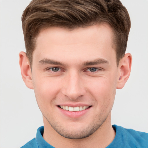 Joyful white young-adult male with short  brown hair and grey eyes