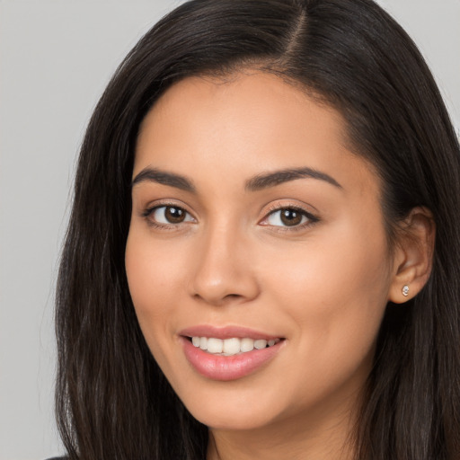 Joyful latino young-adult female with long  brown hair and brown eyes