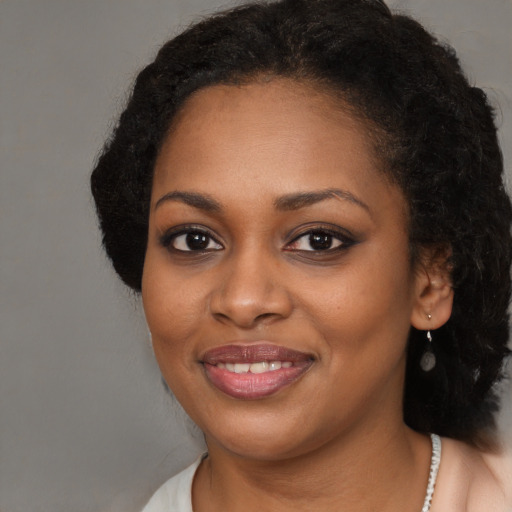 Joyful black young-adult female with long  brown hair and brown eyes