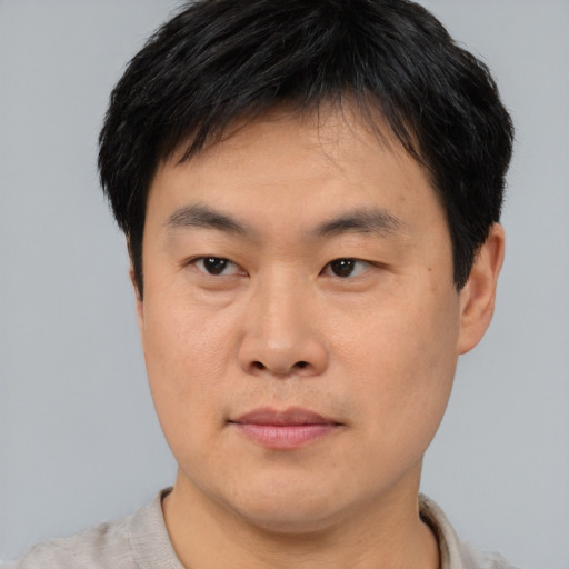 Joyful asian young-adult male with short  brown hair and brown eyes