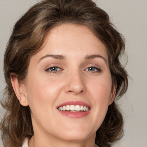 Joyful white young-adult female with medium  brown hair and grey eyes