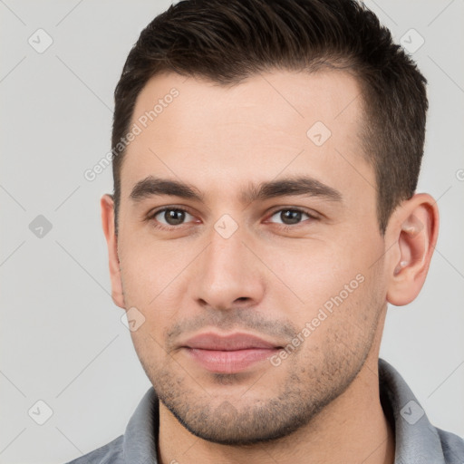 Joyful white young-adult male with short  brown hair and brown eyes