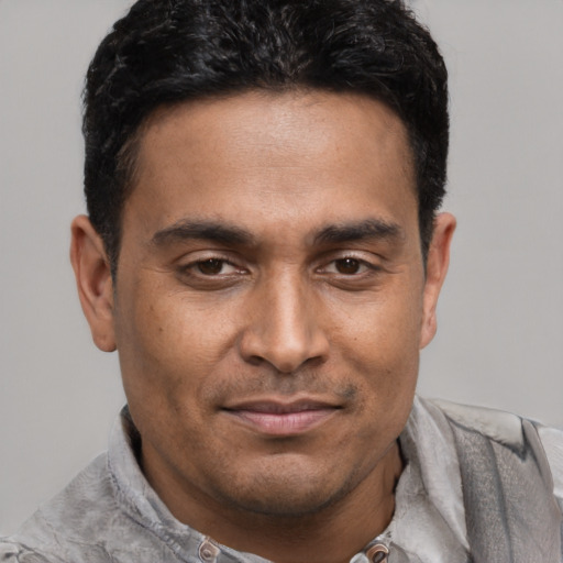 Joyful latino young-adult male with short  black hair and brown eyes