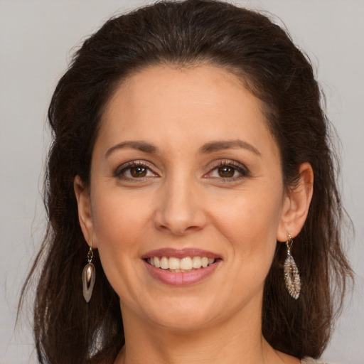 Joyful white adult female with long  brown hair and brown eyes