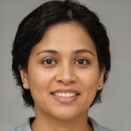 Joyful latino young-adult female with medium  brown hair and brown eyes