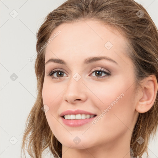 Joyful white young-adult female with long  brown hair and grey eyes