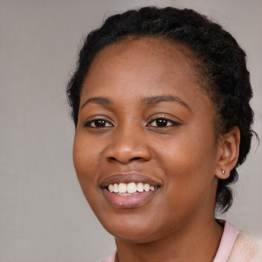 Joyful black young-adult female with short  brown hair and brown eyes