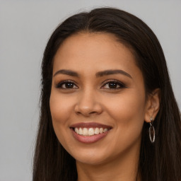 Joyful latino young-adult female with long  brown hair and brown eyes