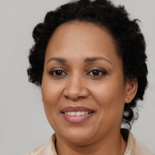 Joyful black adult female with long  brown hair and brown eyes