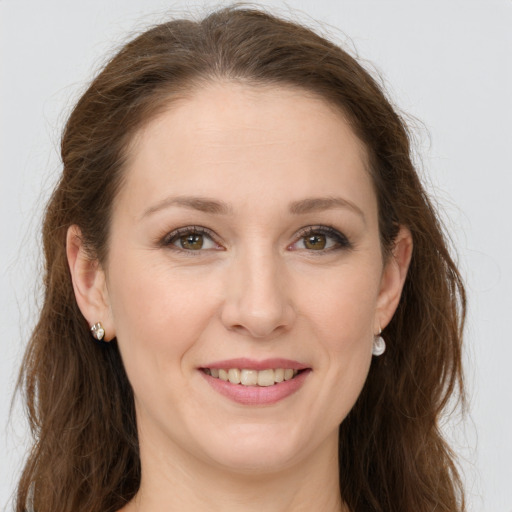 Joyful white young-adult female with long  brown hair and green eyes