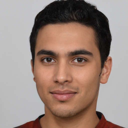 Joyful latino young-adult male with short  black hair and brown eyes