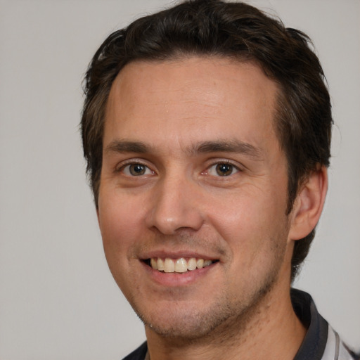 Joyful white young-adult male with short  brown hair and brown eyes