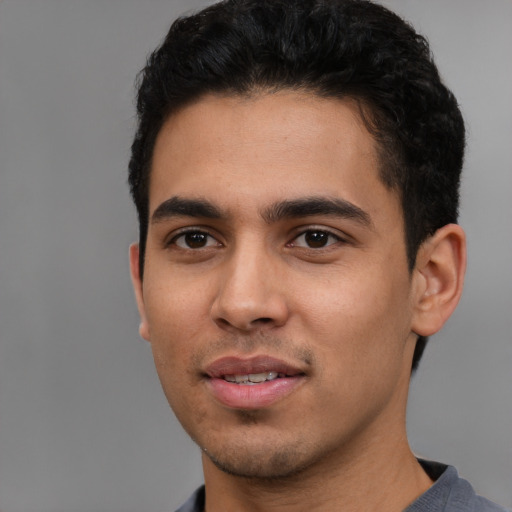 Joyful latino young-adult male with short  black hair and brown eyes