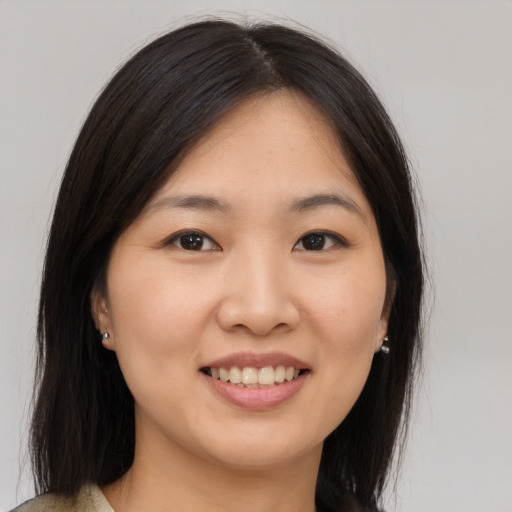 Joyful asian young-adult female with medium  brown hair and brown eyes