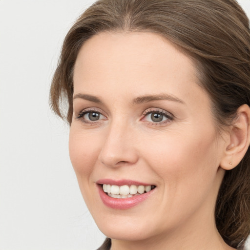 Joyful white young-adult female with long  brown hair and grey eyes