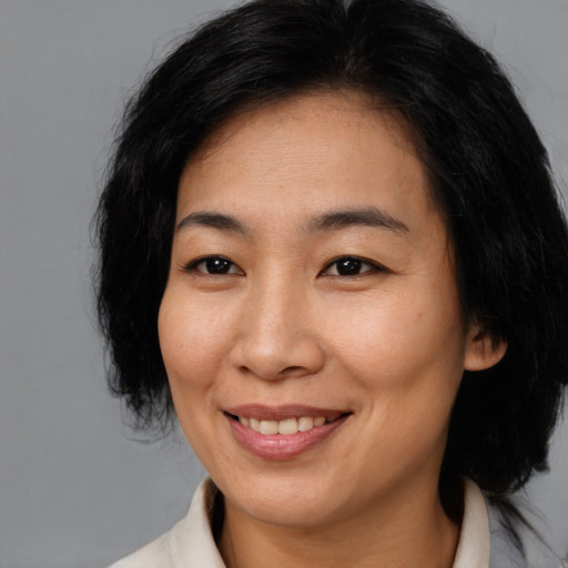 Joyful asian young-adult female with medium  brown hair and brown eyes