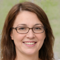 Joyful white adult female with long  brown hair and green eyes