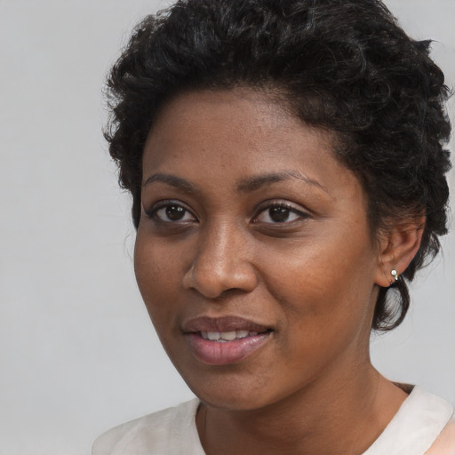 Joyful black young-adult female with short  brown hair and brown eyes