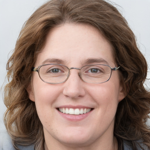 Joyful white adult female with long  brown hair and blue eyes