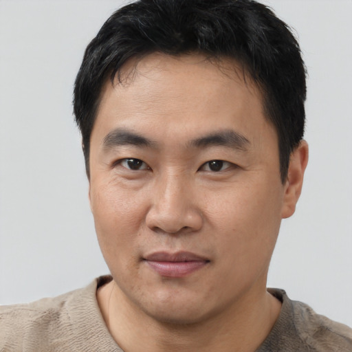 Joyful asian young-adult male with short  black hair and brown eyes