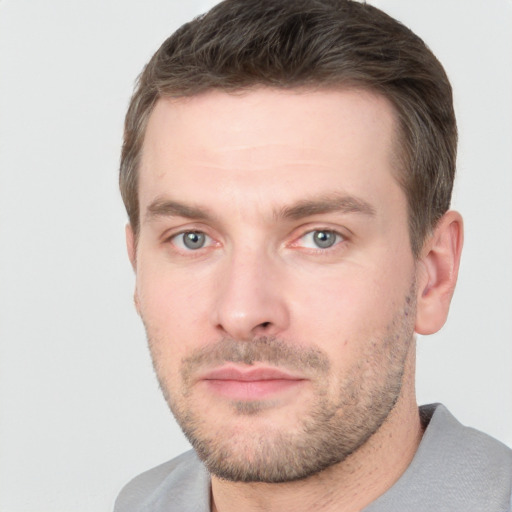 Joyful white young-adult male with short  brown hair and grey eyes