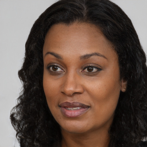 Joyful black young-adult female with long  black hair and brown eyes