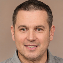 Joyful white adult male with short  brown hair and brown eyes