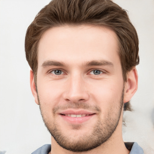 Joyful white young-adult male with short  brown hair and grey eyes