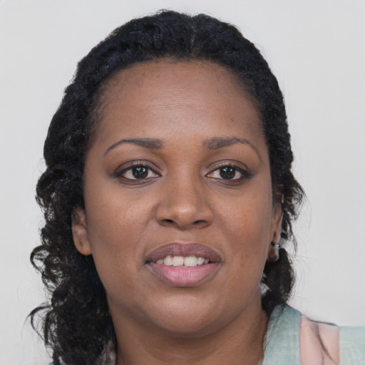 Joyful black young-adult female with long  brown hair and brown eyes