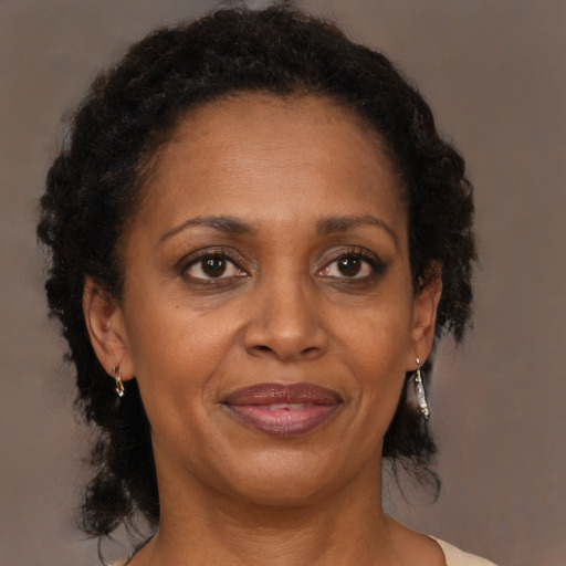 Joyful black adult female with medium  brown hair and brown eyes