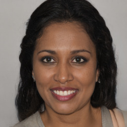 Joyful black young-adult female with medium  brown hair and brown eyes